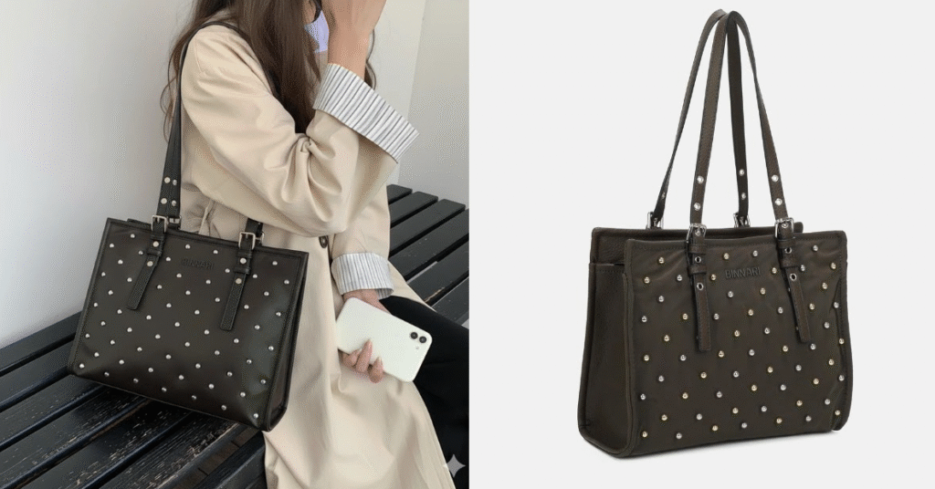Bolso negro con tachuelas metálicas y doble asa, ideal para looks elegantes y urbanos; una opción versátil dentro de los bolsos otoño-invierno, mostrado en modelo y vista de producto.