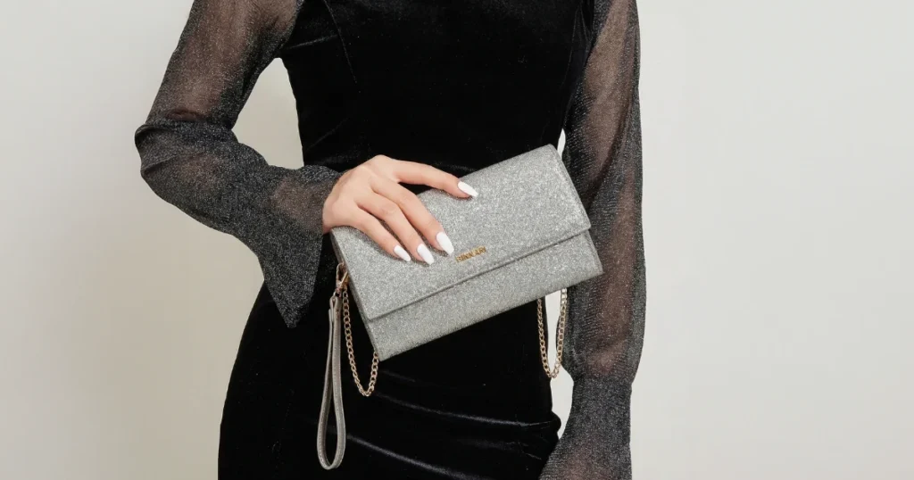Ruzi evening bag by Binnari in the hands of a girl wearing a black dress with sheer sleeves.