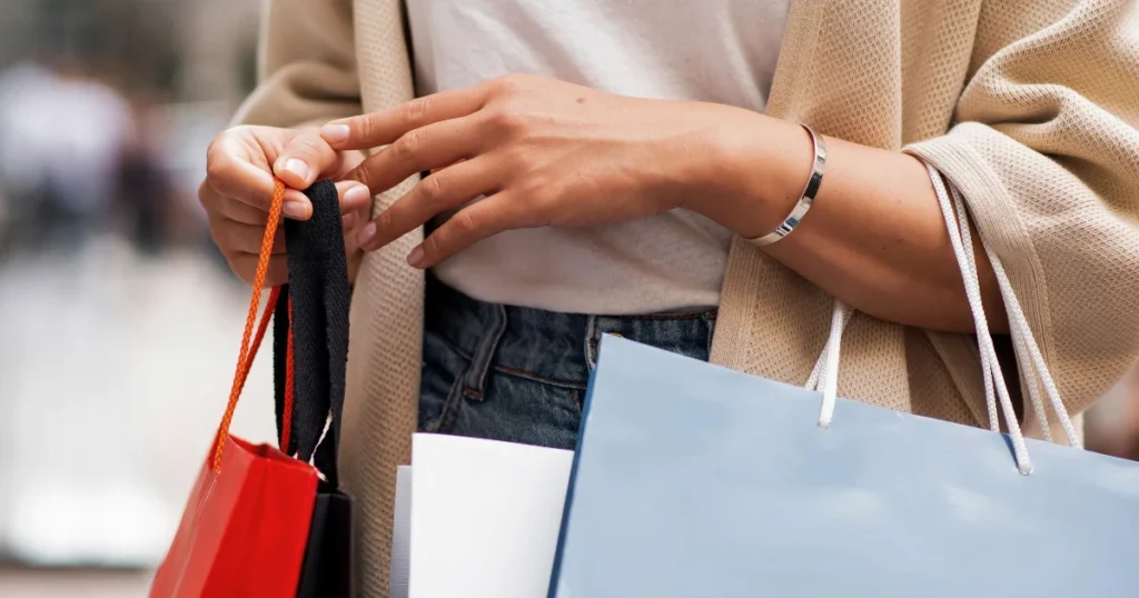 Woman with bags in her arms after learning how to take advantage of the sales on Binnari handbags.